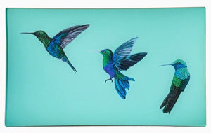 A decorative glass valet tray with three hummingbird illustrations on an aqua background and finished with an 18kt gold leaf edging