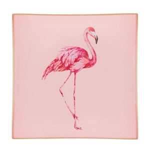A decorative glass tray with a flamingo illustration on a blush pink background finished with an 18kt gold leaf edging