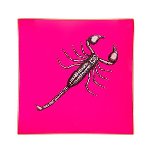 An artisanal, decorative glass valet tray with a scorpion illustration on a neon pink background finished with an 18kt gold leaf edging