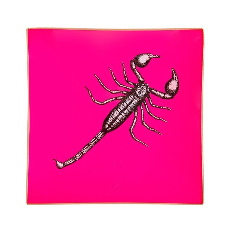 An artisanal, decorative glass valet tray with a scorpion illustration on a neon pink background finished with an 18kt gold leaf edging